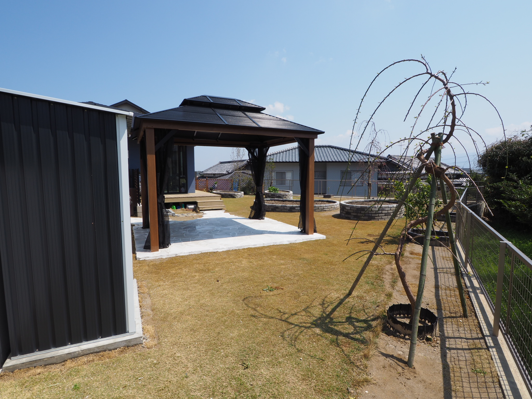 ガゼボの近くに立つ枝垂れ梅